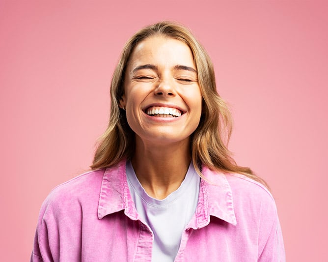 Smilende kvinde med flotte hvide tænder efter kosmetisk tandbehandling på Vesterbro